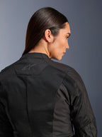 Alpinestars Stella C-1 Air Damenjacke, Textil-Motorradjacke, Schwarz, Nahaufnahme der Rückansicht mit Tech-Mesh-Belüftungseinsätzen und einem reflektierenden Stern-Logo am oberen Rücken, moderne urbane Fahrausrüstung
