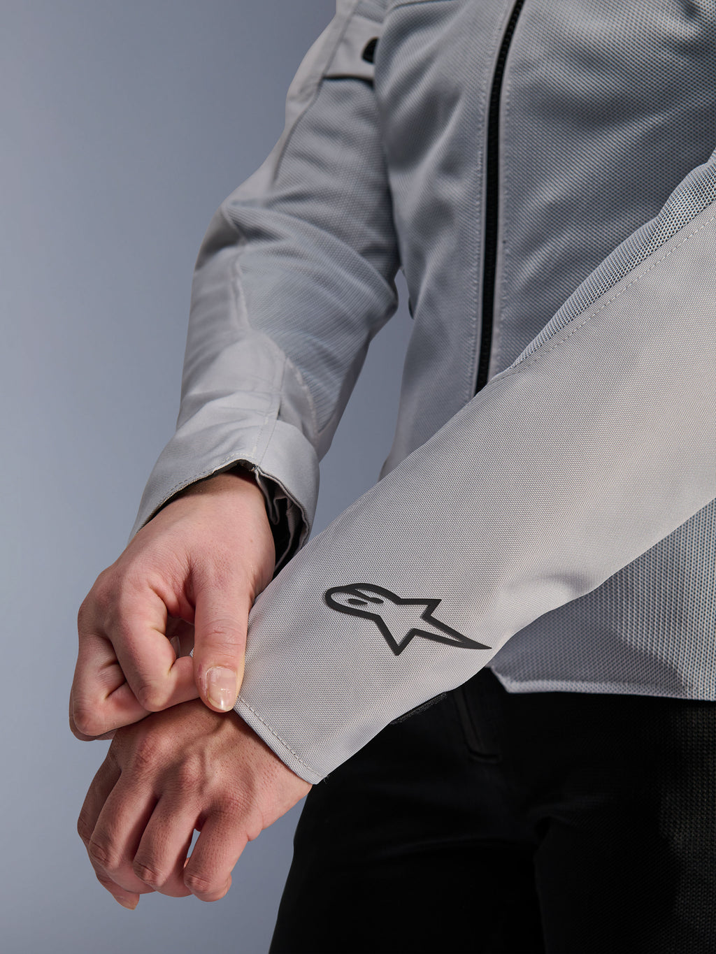 Gros plan de la veste Alpinestars Stella C-1 Air en coloris argent, dotée d'une construction en maille technique et d'un logo Alpinestars noir sur la manche gauche, veste de moto urbaine pour femme avec marquage réfléchissant.