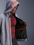 Alpinestars Chrome V2 Sport Hoodie, Motorrad-Hoodie, Grau meliert und Red Fluo, männliches Modell zeigt schwarzes Mesh-Innenfutter und eine rote wasserdichte Tasche, mit rotem Branding auf der Kapuze und Tech-Air Ready-Label, lässige sportliche Silhouette für Fahrten in der Stadt