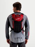 Alpinestars AT-9 Rucksack, Motocross-Rucksack, Schwarz und Rot, getragen von einem Model von hinten mit leichter Textilkonstruktion und gepolstertem Gurtsystem