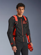 Alpinestars MM93 AMP3 rugzak, fluo rood en zwart, gedragen door een model met een bijpassende zwart-rode MM93 motorjas en handschoenen, vooraanzicht met nadruk op de verstelbare schouderbanden en borstsluiting, technische op racing geïnspireerde uitrusting.