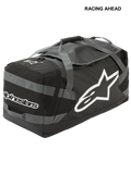 Alpinestars Goanna Tasche, Motocross-Duffletasche, Schwarz und Anthrazitgrau mit weißen Logos, großes seitliches Stern-Logo und Schriftzug, strapazierfähiger Boden aus Planenmaterial, verstärkte Trageriemen, großer Stauraum für Offroad-Rennausrüstung