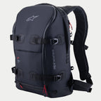 Sac à dos Alpinestars AMP-7, sac à dos technique de moto, noir avec accents de fermetures éclair rouges, doté de quatre sangles de compression réglables à boucles, parois rembourrées structurées, logo Alpinestars sur le dessus et marquage latéral, bretelles ergonomiques pour l'aventure et le touring routier