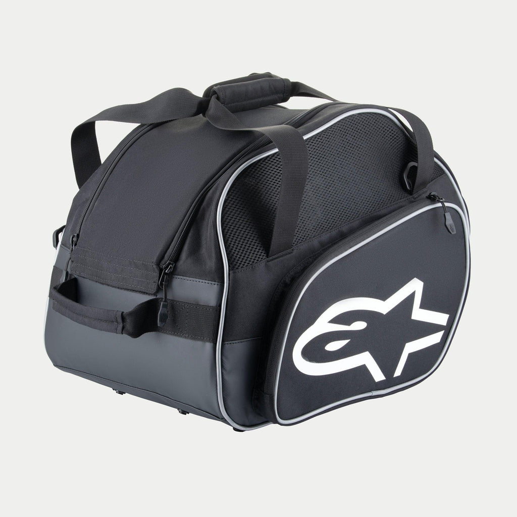 Sac pour casque Alpinestars Flow V3, rangement de protection pour casques intégraux, noir et blanc, avec un grand logo blanc sur le côté, des panneaux de ventilation en mesh et des poignées de transport renforcées, conception en polyester durable pour équipement de course.
