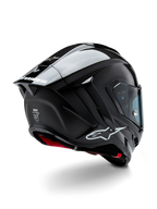 Casque Alpinestars Supertech R10 Solid, casque de course moto, finition carbone noir mat et brillant, vue de trois-quarts arrière montrant la coque en fibre de carbone, le spoiler aérodynamique et le logo Alpinestars.