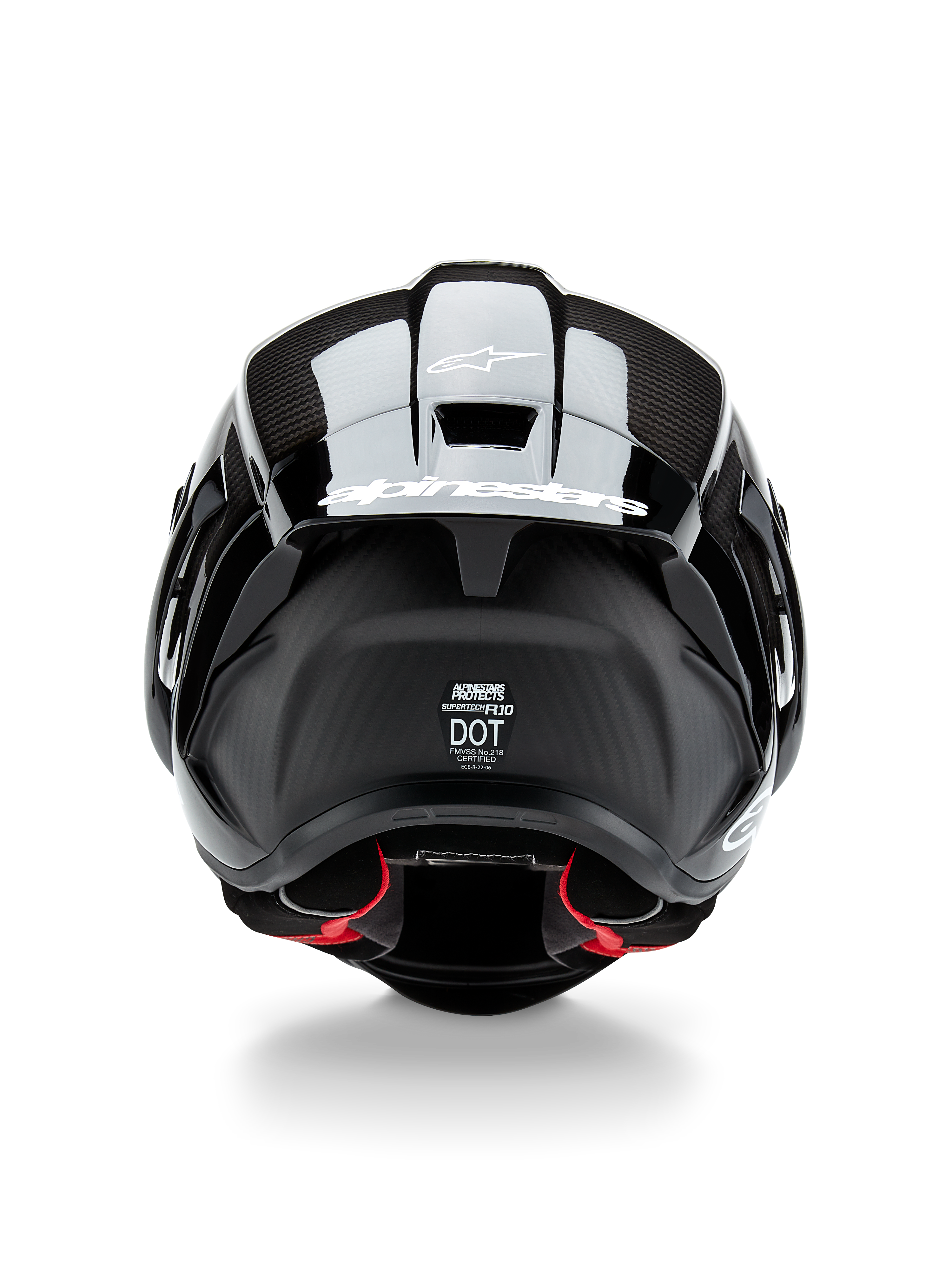 Casque Alpinestars Supertech R10 Solid, casque de moto, noir carbone mat et brillant, vue arrière avec texture en fibre de carbone, spoiler aérodynamique avec logo Alpinestars blanc, étiquettes de certification de sécurité DOT et ECE, et rembourrage intérieur rouge