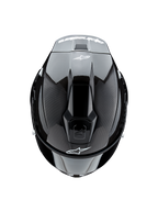 Casque Alpinestars Supertech R10 Solid, vue de dessus, carbone noir mat et brillant, montrant la texture de la fibre de carbone sur les côtés, la section centrale brillante, les ventilations aérodynamiques et le logo Alpinestars blanc à l'avant et à l'arrière