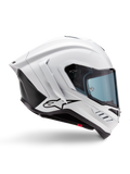 Casque Alpinestars Supertech R10 Solid, casque de moto racing blanc brillant et noir mat, vue de profil, design aérodynamique avec ailerons arrière et évents latéraux, visière teintée bleu, arborant un logo étoile Alpinestars noir sur le côté