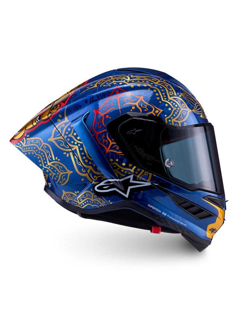 Casque Alpinestars Supertech R10 Martinator Thai en carbone bleu brillant, mandalas dorés complexes et profil de course.