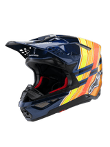 Alpinestars Supertech M10 TLD Edition 25 helm, motorcrosshelm, glanzend donkerblauw met oranje en gele fluo graphics, rode binnenvoering, aerodynamische schaal met meerdere ventilatieopeningen, Troy Lee Designs branding op de klep, professionele off-road race-uitrusting