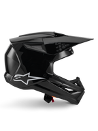 Alpinestars S-M3 Solid helm, motorcrosshelm, glanzend zwart, zijaanzicht met een wit sterlogo, hoekig aerodynamisch ontwerp met ventilatieopeningen en vizier, beschermende off-road race-hoofdbescherming