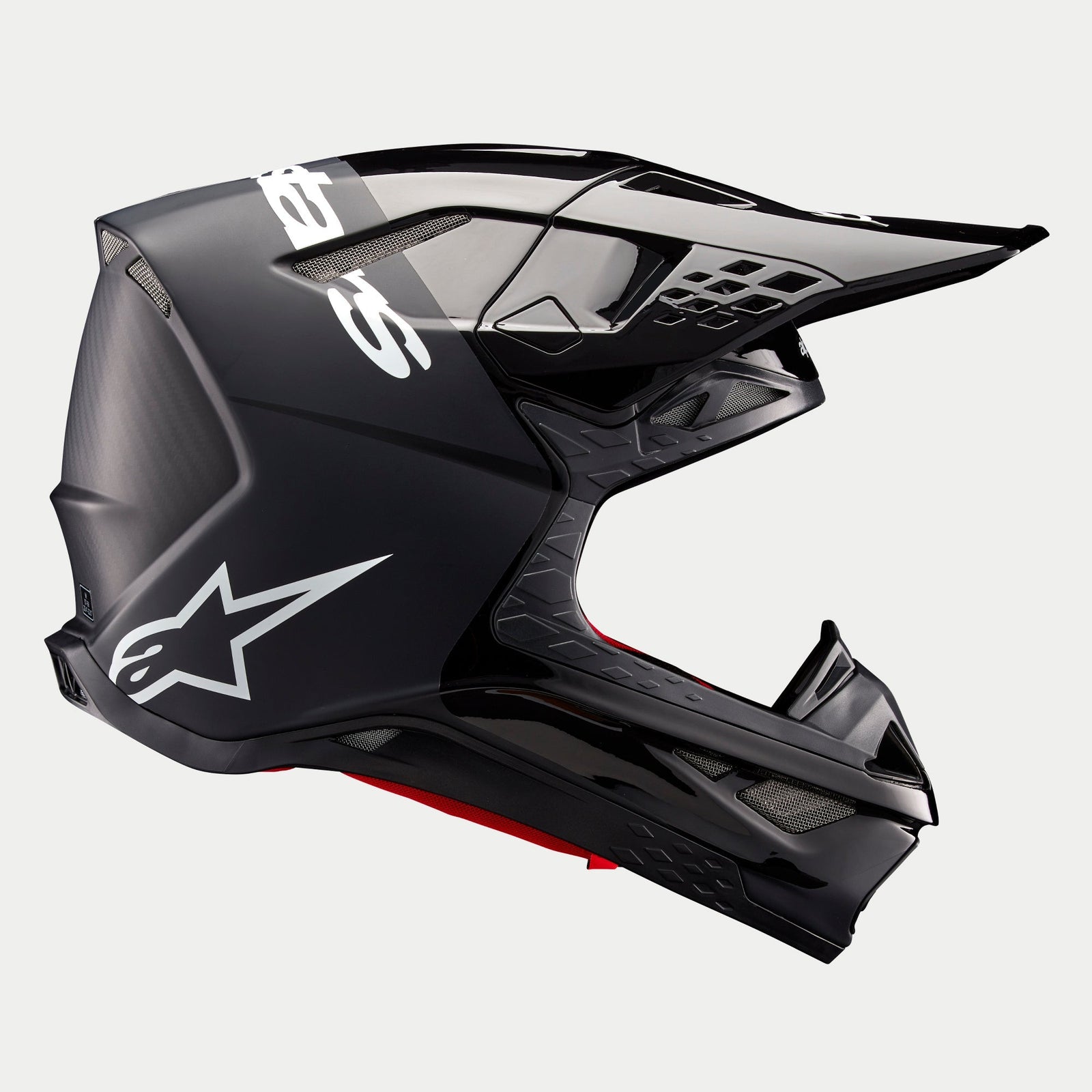 Alpinestars Supertech M10 Flood Helmet ECE, casque de motocross, noir et gris foncé avec finition mate et brillante, vue de profil présentant un design aérodynamique, une visière intégrée et le logo Alpinestars blanc