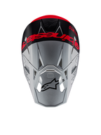 Casque Alpinestars Supertech M10 Flood ECE 22.06, casque de motocross, argent et noir avec orange fluorescent, vue de dessus montrant un logo imposant sur le sommet, logo Astars noir sur la visière, profil aérodynamique épuré avec ports de ventilation, textures mates et brillantes.