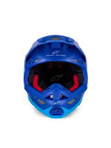 Alpinestars Supertech M10 Flood helm ECE, motorcrosshelm, metallic en medium blauw met zwarte carbonaccenten, vooraanzicht met kinstuk en oogopening, witte Alpinestars-logo's en tekst, rode binnenvoering, professionele off-road bescherming