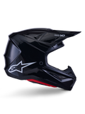 Alpinestars S-M7 Solid Helmet, Motocross Racing Helmet, Glossy Black with White Star Logo and Red Accents, side profile featuring aerodynamic design with angular mesh vents and Supertech M7 branding on the visor.