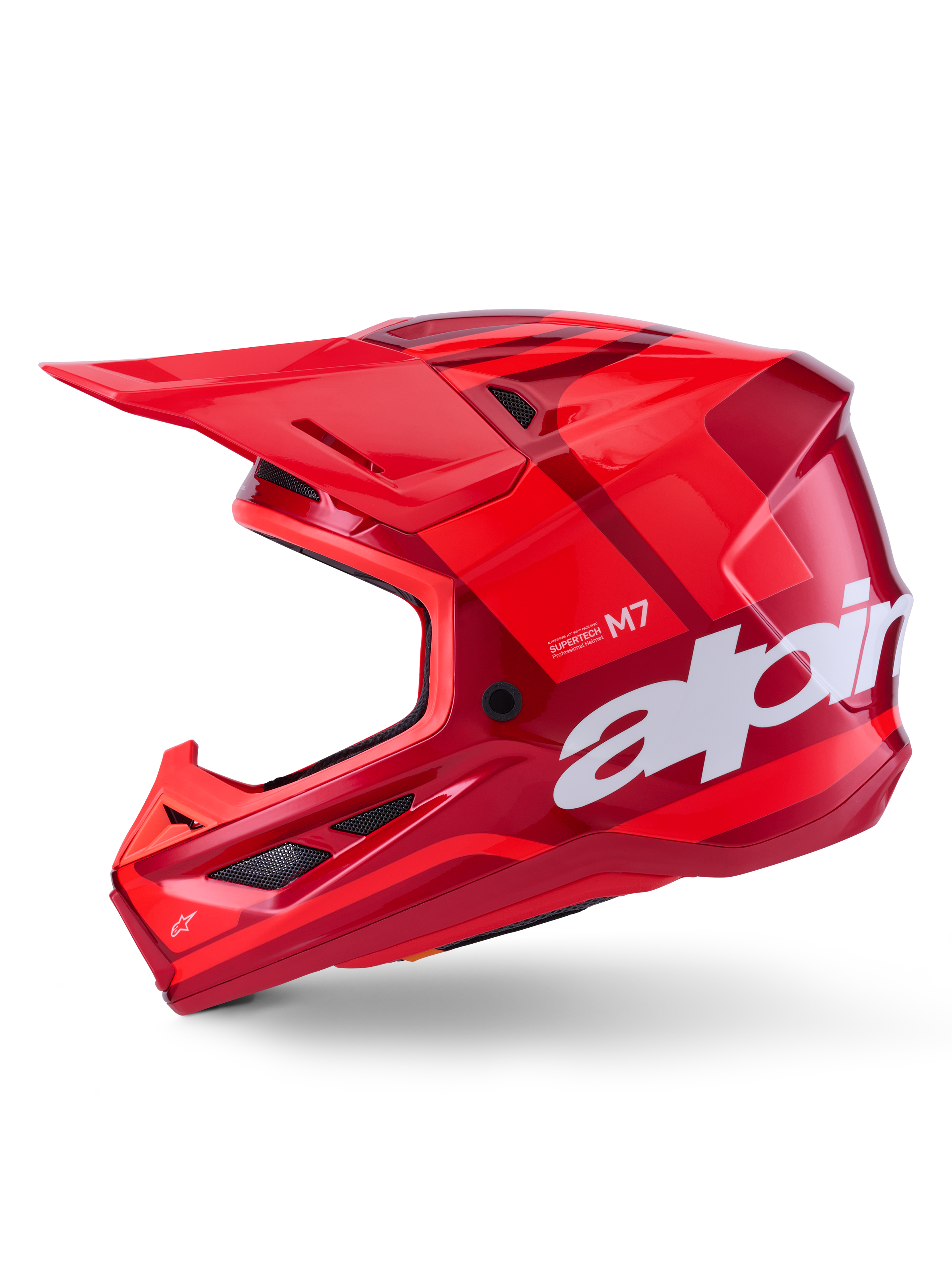 Alpinestars S-M7 Core Helm, glanzend rood met geometrische accenten, motorcrosshelm, zijaanzicht, aerodynamische schaal met ventilatieopeningen en witte logo's, hoogwaardige off-road race-uitrusting