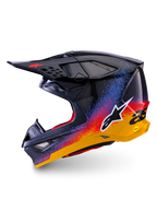 Casque Alpinestars Supertech M10 Black Hole en édition limitée, casque de motocross, finition brillante Black Burst avec éclaboussures en dégradé de bleu, rouge et jaune éclatants, vue de profil latéral montrant le logo Astars blanc et les textures de la coque en fibre de carbone.