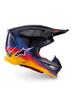 Alpinestars Limited Edition Supertech M10 Black Hole, casque de motocross, coque noire avec motifs d'éclaboussures dégradés rouges, bleus et jaunes, logo étoile blanc sur le côté, profil aérodynamique avec orifices de ventilation grillagés, rembourrage intérieur rouge et longue visière noire