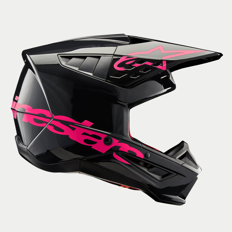 Alpinestars S-M5 Corp Helm, Motocross-Helm, Schwarz Diva Pink Glänzend, Seitenansicht, glänzendes schwarzes Finish mit leuchtend pinkem Branding, aerodynamische Schale mit Belüftungsöffnungen für Schutz beim Offroad-Rennsport