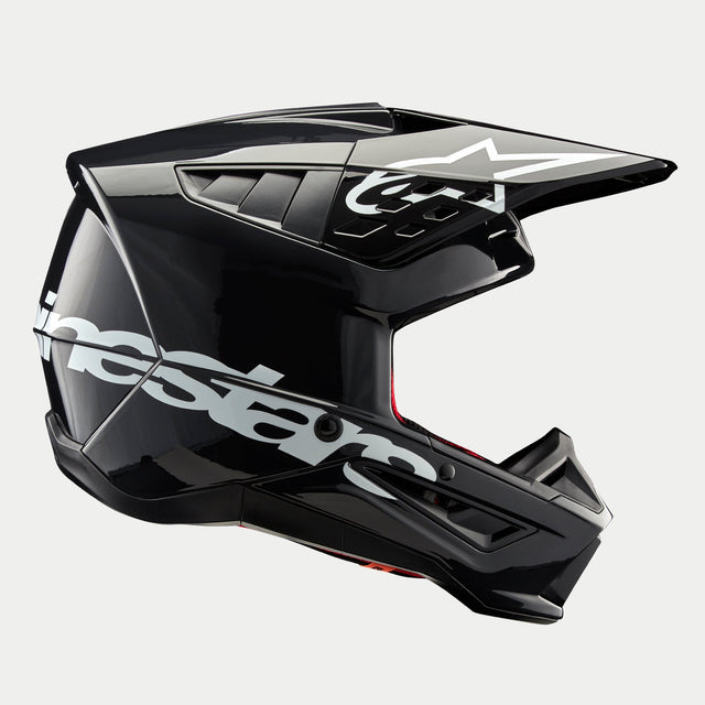 Casque Alpinestars S-M5 Corp, casque de motocross, gris foncé brillant, vue de profil avec un grand logo Alpinestars blanc, logo d'étoile blanche sur la visière, aérations aérodynamiques profilées, finition brillante, protection pour la course tout-terrain