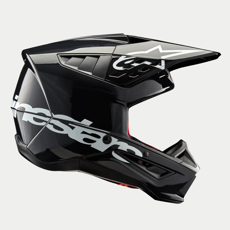 Casque Alpinestars S-M5 Corp, casque de motocross, gris foncé brillant, vue de profil avec un grand logo Alpinestars blanc, logo d'étoile blanche sur la visière, aérations aérodynamiques profilées, finition brillante, protection pour la course tout-terrain