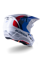Alpinestars Honda S-M5 ECE-helm, motorcrosshelm, glanzend wit, blauw en rood, met opvallende Honda-branding en Alpinestars-logo's, aerodynamische schaal met geïntegreerde ventilatieopeningen en verstelbaar vizier, beschermende uitrusting voor off-road racen