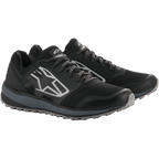 Chaussures Alpinestars Meta Trail, chaussures de course performantes, noir et gris foncé, grand logo Astars blanc rayé sur le côté, conception à lacets avec une semelle grise robuste, conçues pour un confort tout au long de la journée dans le paddock