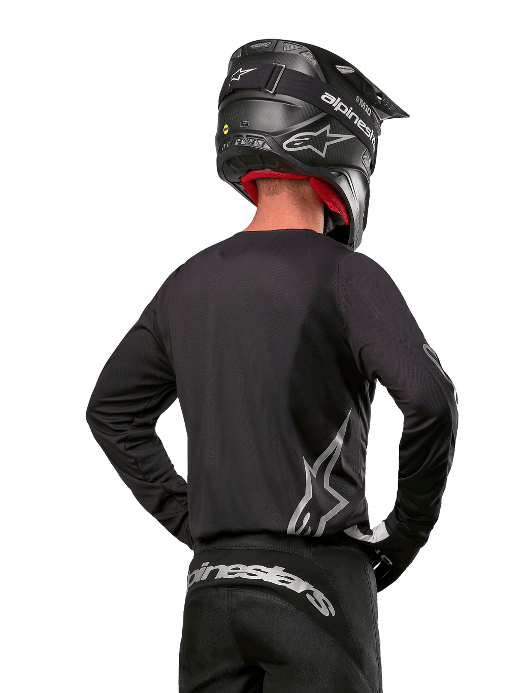 Alpinestars 2024 Fluid Graphite Gear Set, Motocross Jersey and Pants, Graphite and Silver, back view featuring silver branding on lower back and waist, worn with black carbon-effect helmet, lightweight poly-fabric design for off-road riding