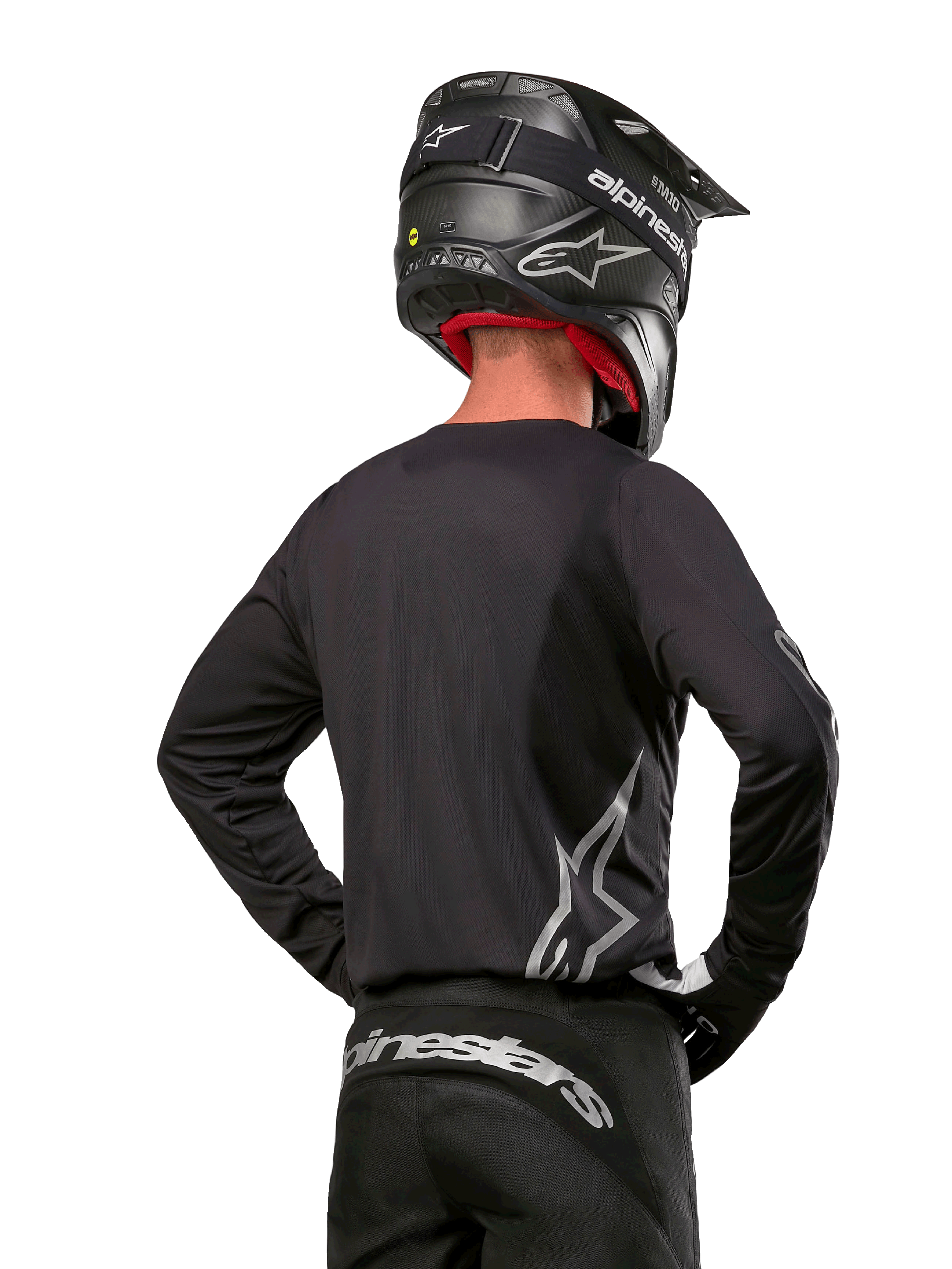 Alpinestars 2024 Fluid Graphite Gear Set, Motocross Jersey and Pants, Graphite and Silver, back view featuring silver branding on lower back and waist, worn with black carbon-effect helmet, lightweight poly-fabric design for off-road riding