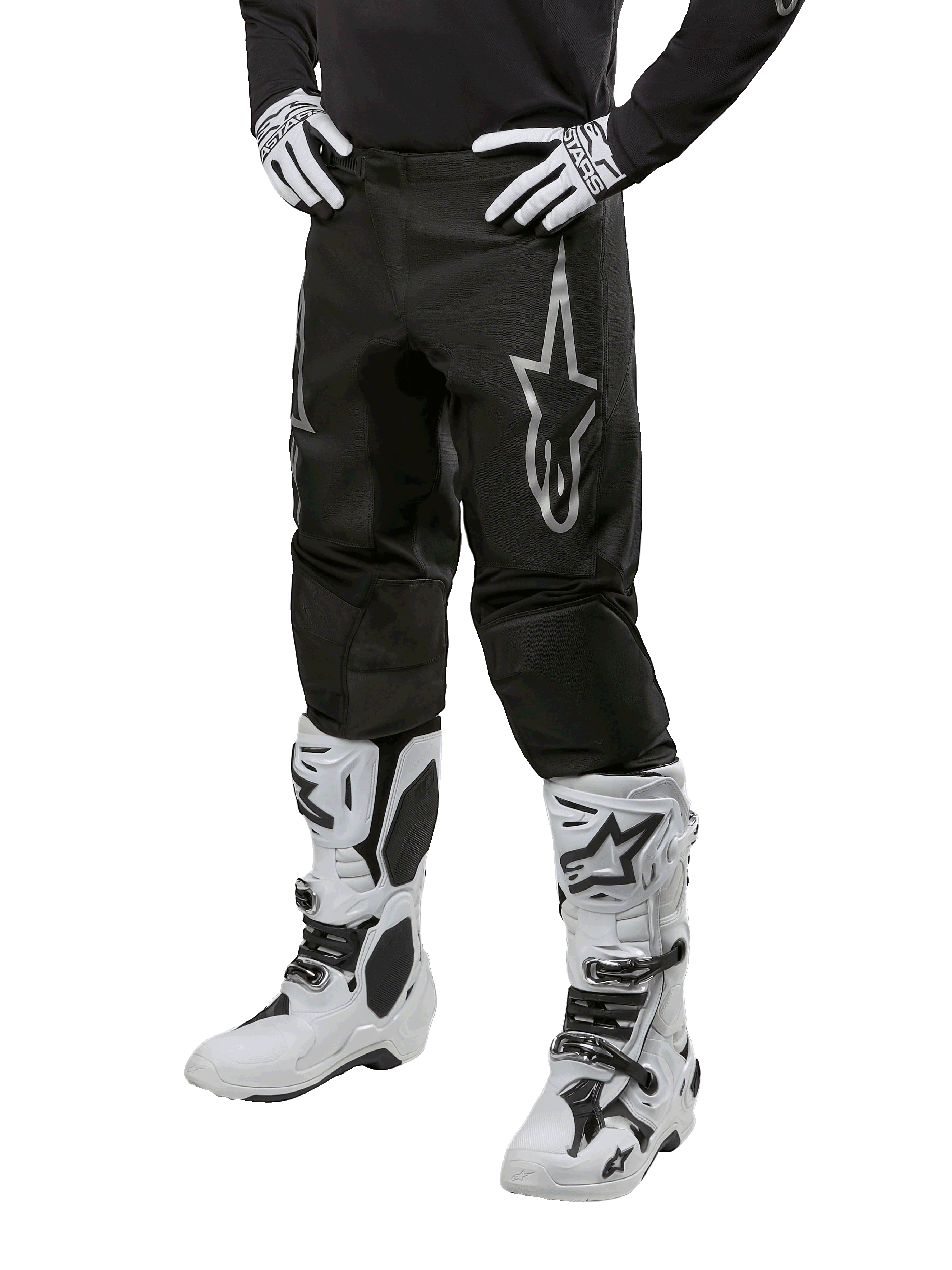 Alpinestars 2024 Fluid Graphite Hose, Motocross-Hose, Schwarz und Silber, mit silbernem Alpinestars-Logo auf dem Oberschenkel, gezeigt mit weißen Motocross-Stiefeln und Handschuhen, entworfen für Offroad-Motorradrennen