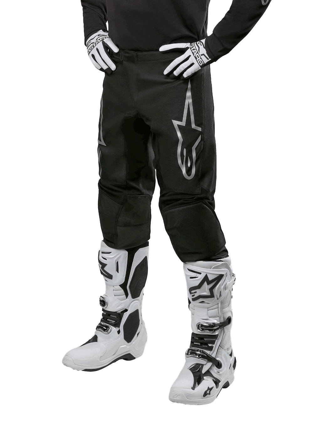 Alpinestars 2024 Fluid Graphite Pants, Motocross Pants, Gray and Black, worn with white and black motocross boots and gloves, featuring a large silver Alpinestars logo on the thigh, athletic sport fit for off-road riding
