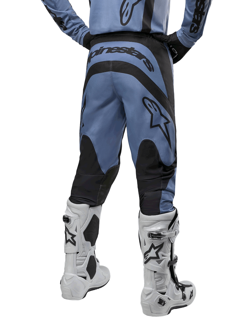 Alpinestars 2024 Fluid Lurv Pants, pantalon de motocross, bleu clair et noir, vue arrière montrant les panneaux renforcés noirs et le grand logo de la marque, associé à des bottes de motocross blanches et noires, équipement de course professionnel pour le tout-terrain