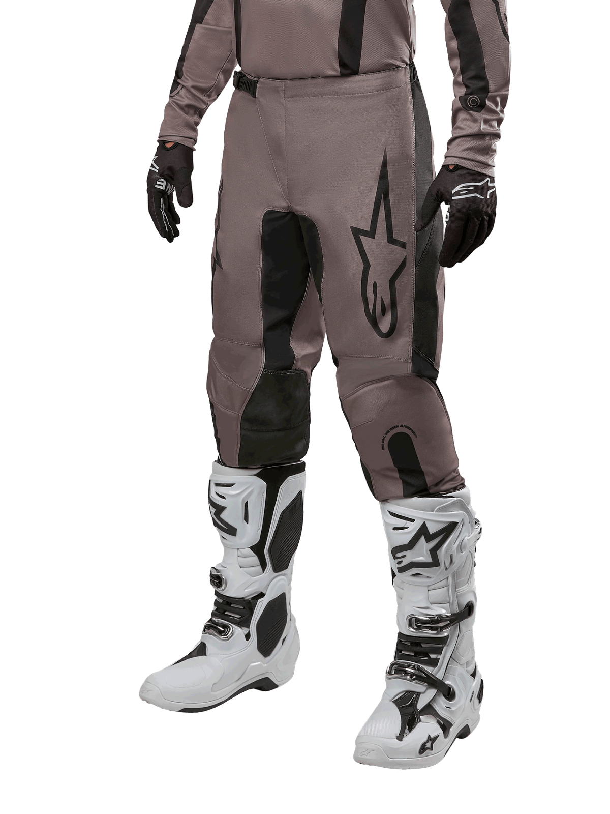Alpinestars 2024 Fluid Lurv Hose, Motocross-Hose, Mud Black und Schwarz, mit Alpinestars-Logo, getragen mit schwarzen Handschuhen und weißen Motocross-Stiefeln, sportliches Design für Offroad-Rennsport
