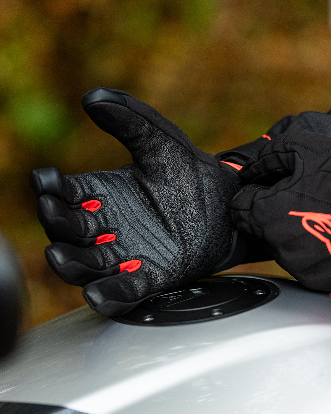 Alpinestars Faster V3 Plasma Drystar Gloves, waterproof motorcycle riding gloves, black and red, showing leather palm construction and ergonomic fit worn by a rider