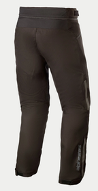 Pantalon imperméable Alpinestars AST-1 V2 - Court, pantalon de moto noir, vue arrière avec construction textile durable, logo Alpinestars réfléchissant sur le bas de la jambe, fermeture éclair de raccordement à la taille et ceinture réglable par bande auto-agrippante