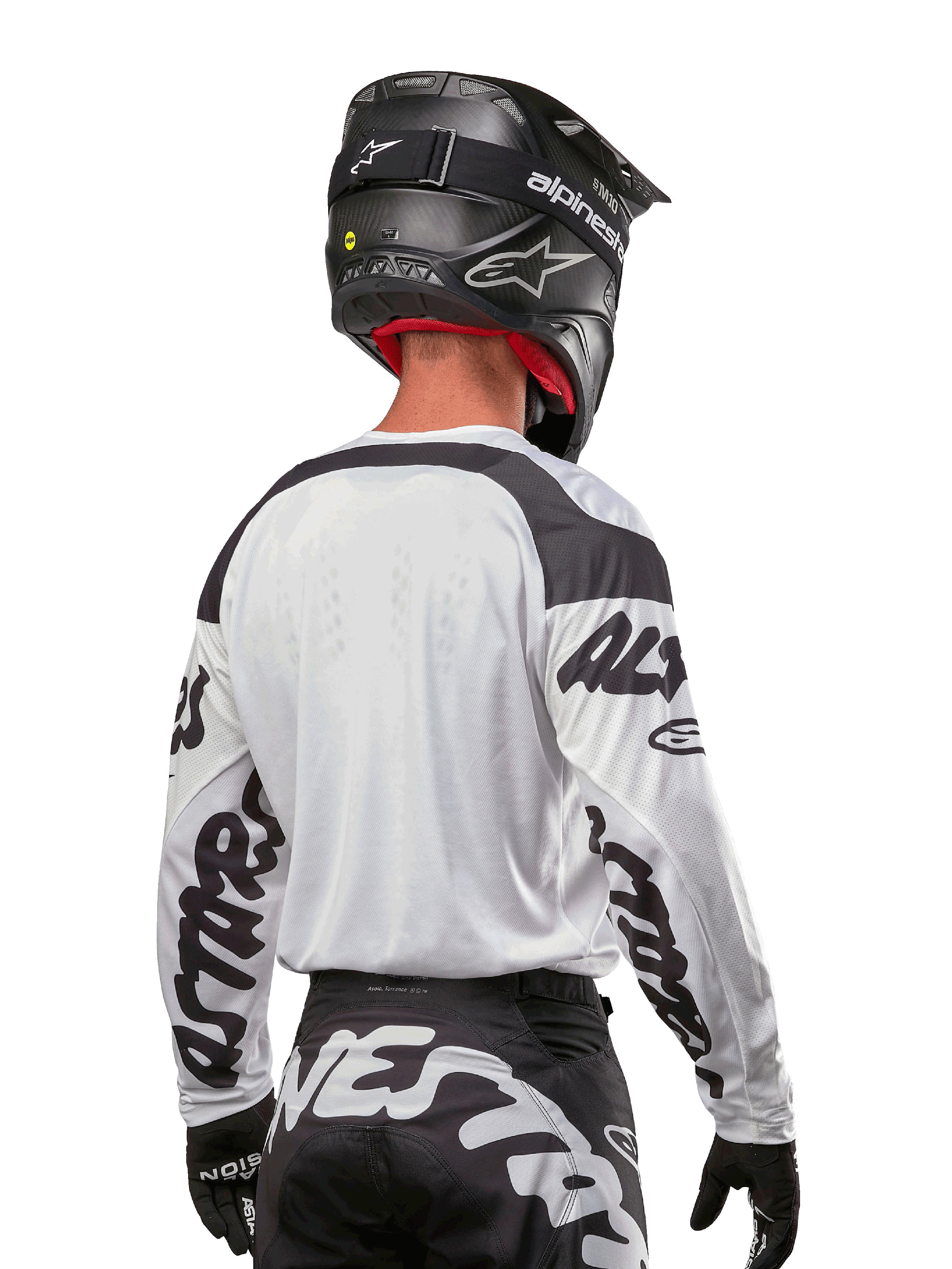 Alpinestars 2024 Racer Hana Trikot, Weiß und Schwarz, Rückansicht zeigt ergonomische Passform und markantes Ärmel-Branding, kombiniert mit einem schwarzen Motocross-Helm und dazu passender schwarz-weißer Hose, Hochleistungs-Rennausrüstung für Offroad-Fahrten