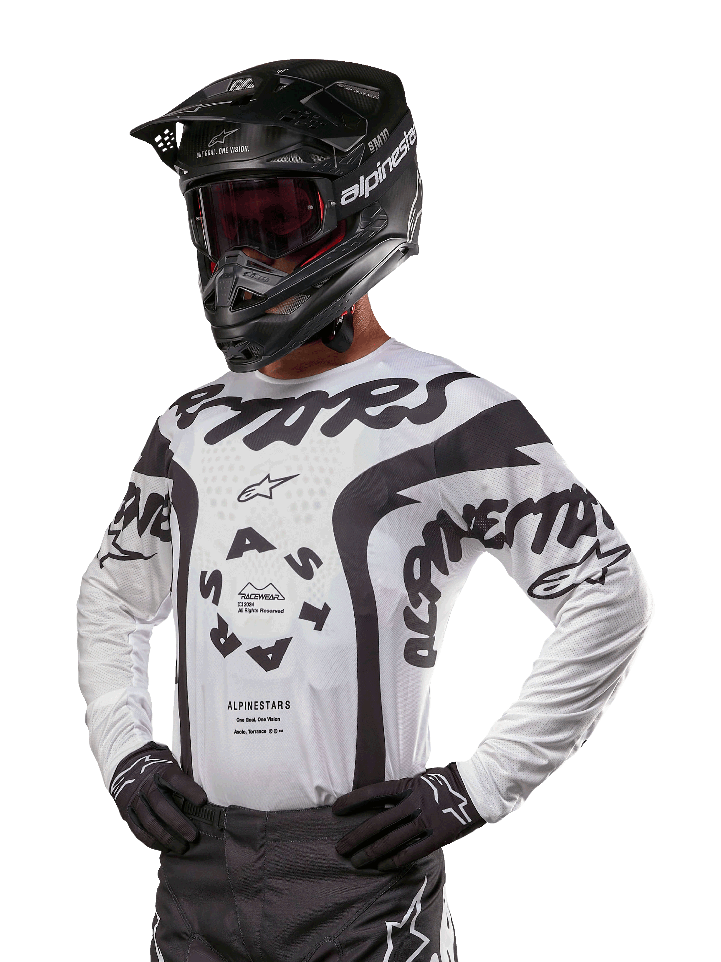 Maillot Alpinestars Racer Hana 2024, maillot de course de motocross, blanc et noir, graphismes audacieux avec marquages Alpinestars et Astars, porté avec casque noir et gants noirs, équipement de motocross tout-terrain haute performance