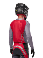 Motocross-Fahrer von hinten, Alpinestars 2024 Supertech Dade Jersey in Iron Red Berry und Grau, atmungsaktives Mesh-Rückenteil, silberne Logo-Akzente, schwarzer Helm und passende Rennhose, professionelle Offroad-Performance