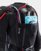 Alpinestars Tech-Air® Off-Road Systeem, zwart-rood mesh beschermjas met blauwe drinkzak en honingraat rugbeschermer.