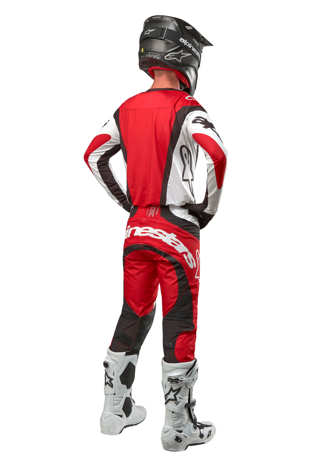Alpinestars 2024 Techstar Ocuri Pants, pantalon de motocross, Mars Red White Black, vue arrière d'un pilote portant un équipement de course complet, incluant le maillot assorti, un casque noir et des bottes blanches et noires, mettant en avant le logo Alpinestars et la construction en tissu durable.