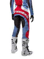 Alpinestars 2024 Techstar Ocuri Pants, pantalon de motocross, bleu clair, rouge Mars et blanc, vue arrière mettant en évidence le grand logo Alpinestars rouge sur l'assise, porté avec des bottes de course blanches et un maillot assorti.