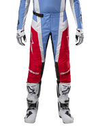 Alpinestars Techstar Ocuri Pants 2024, pantalon de motocross, bleu clair, rouge Mars et blanc, vue de face à partir de la taille, associé à des bottes et des gants de motocross blancs et noirs, équipement technique conçu pour la course tout-terrain haute performance.