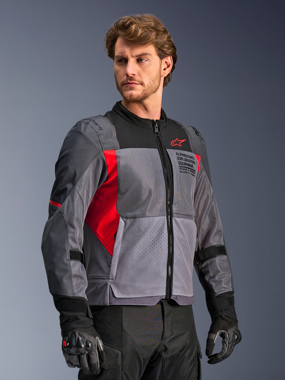Alpinestars ST-2 Air jas, grijs en rood mesh touring motorjas voor heren met laserperforaties, gedragen door een model.