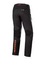 Alpinestars AMT-10R Drystar® XF broek, zwart met oranje accenten, achteraanzicht met verticaal oranje Alpinestars-logo op het linkerbeen, getextureerde kniepanelen en Kevlar- en Matryx-branding, technische adventure touring motorbroek.