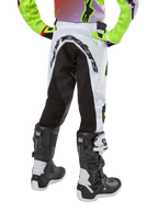 Alpinestars Youth 2024 Racer Lucent Hose, Motocross-Hose, Weiß und Schwarz mit Neon-Akzenten, Rückansicht mit großem hinterem Stretch-Panel und Alpinestars-Logo, kombiniert mit schwarz-weißen Alpinestars Tech Series Stiefeln.