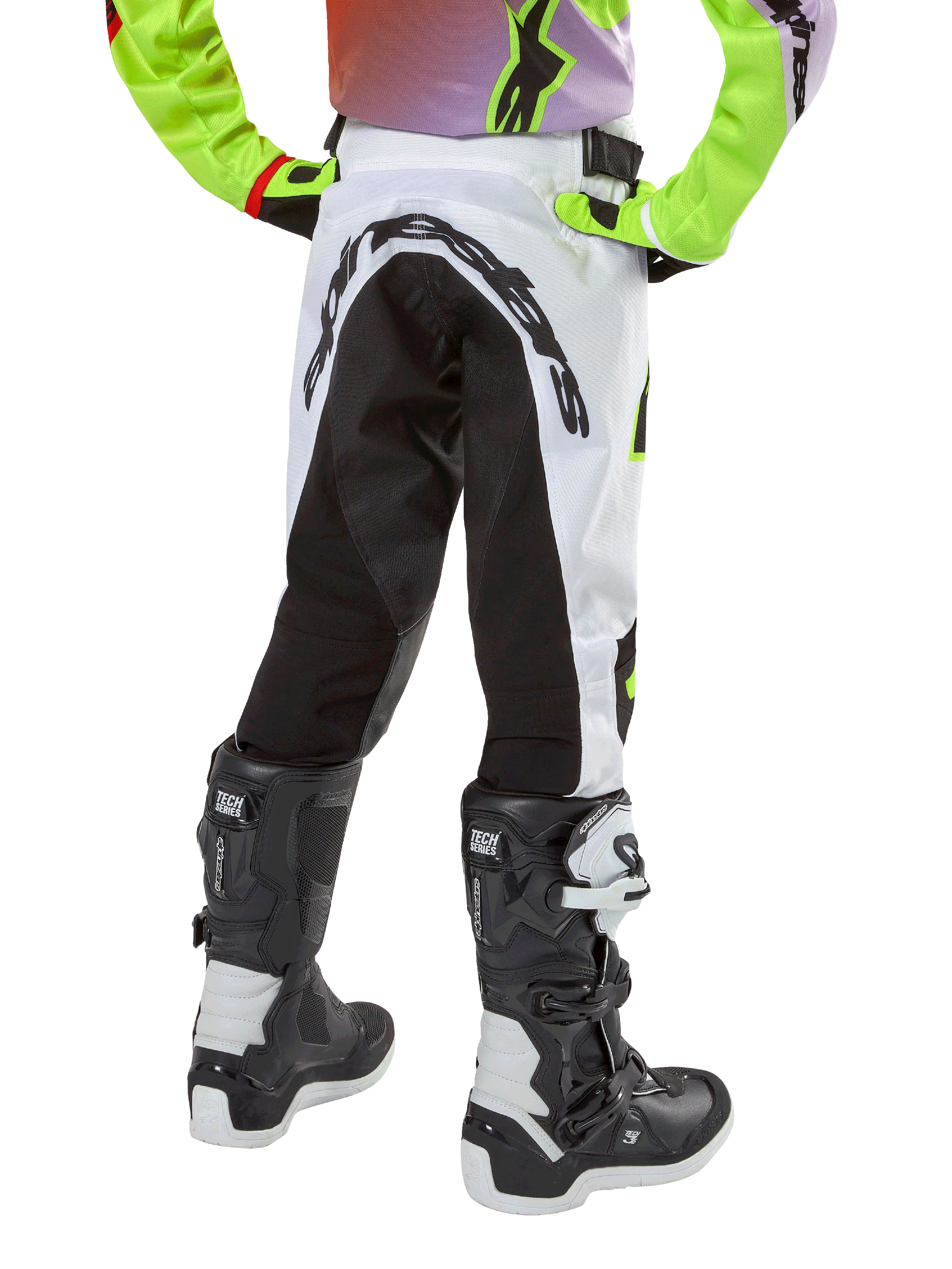 Alpinestars Youth 2024 Racer Lucent Hose, Motocross-Hose, Weiß und Schwarz mit Neon-Akzenten, Rückansicht mit großem hinterem Stretch-Panel und Alpinestars-Logo, kombiniert mit schwarz-weißen Alpinestars Tech Series Stiefeln.