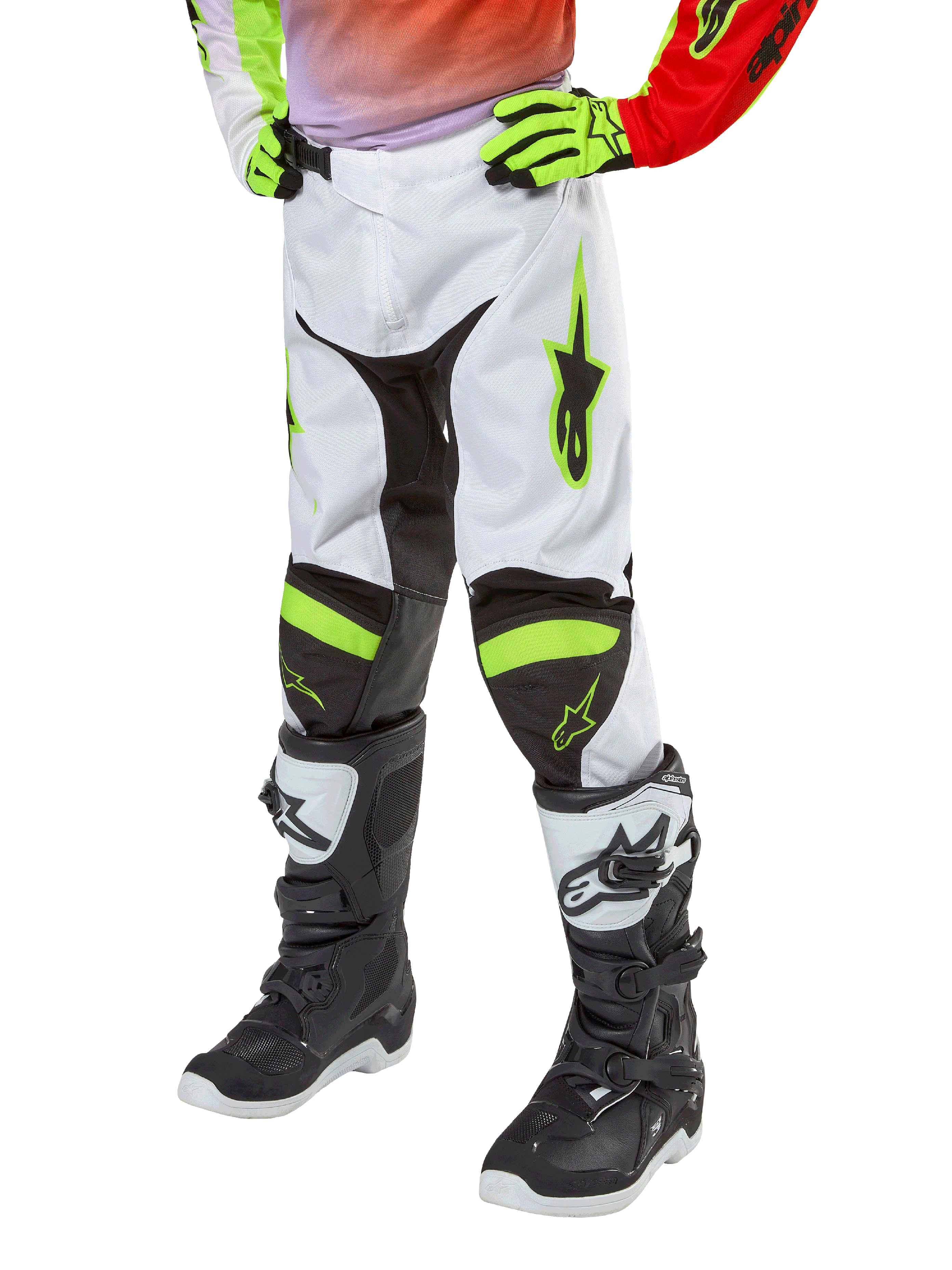 Alpinestars Youth 2024 Racer Lucent motorcrossbroek, crossbroek, wit, neonrood en geel fluo, weergave van het onderlichaam met zwarte stretchpanelen en neonaccenten, gedragen met zwart-witte racelaarzen en neongele handschoenen, technische off-road uitrusting voor de jeugd