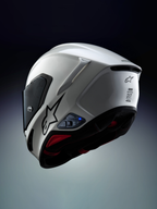 Alpinestars A-Connect Intercom-System, installiert an einem Alpinestars S-R7 Motorradhelm in Weiß und Schwarz, mit Bluetooth-Steuereinheit und blauer LED-Statusleuchte