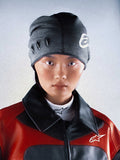 Alpinestars RSRV Onyx Beanie, bonnet gris foncé avec détails œillets noirs et logo blanc, porté avec veste rouge et noire, style urbain premium