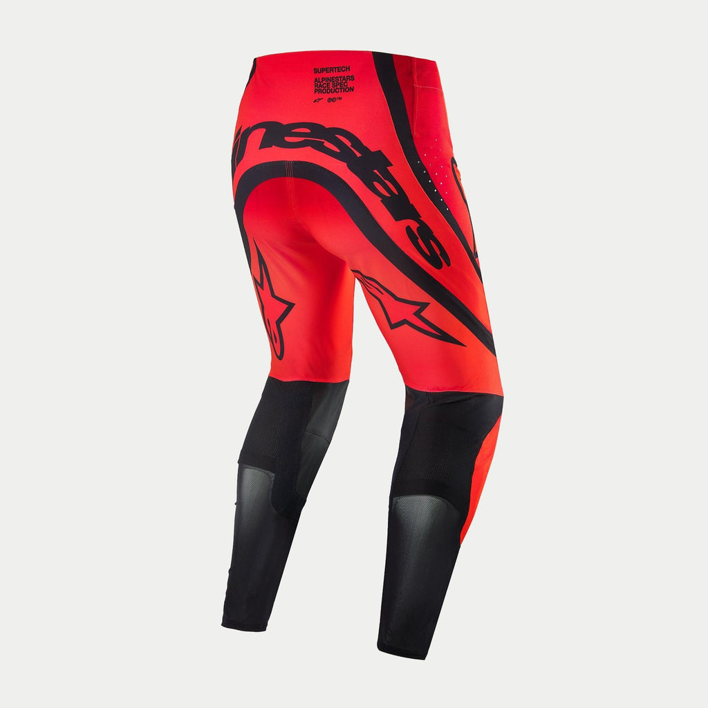 Pantalon Alpinestars Supertech Ember LE, pantalon de motocross, rouge fluo et rouge vif avec des accents noirs, vue arrière présentant un marquage Alpinestars noir imposant sur l'assise, des logos étoilés sur les cuisses et des panneaux en mesh technique sur le bas des jambes.